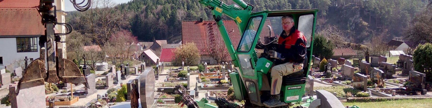 Grabaushub mit speziellem Friedhofsbagger für eine Erdbestattung am Friedhof in Nankendorf